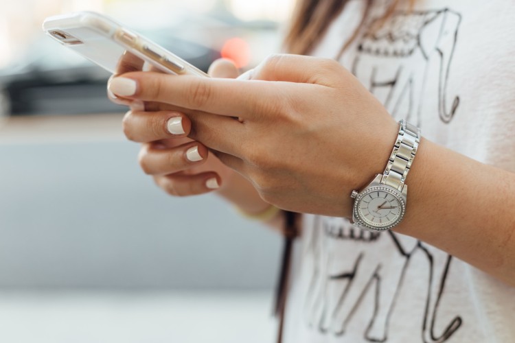 Ragazza armeggia su iphone Ricarica telefonica Kena Mobile con bitcoin e criptovalute