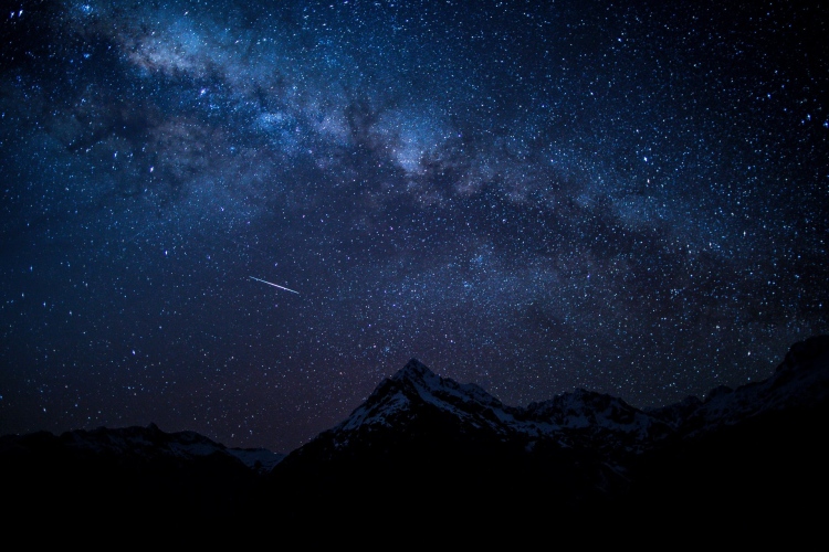 Cielo stellato solcato da stella cadente e montagne innevate Come comprare Stellar Lumens (XLM)