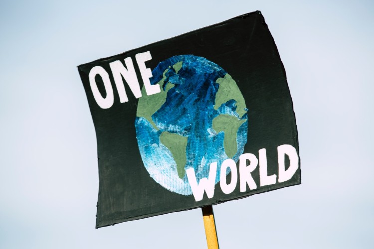 Pianeta con slogan One World Cambiamento climatico e l'arma del boicottaggio